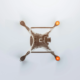 Top-down view of a white quadcopter drone with a high-definition camera mounted on its central body. Four arms extend outward, each ending with an orange warning light, showcasing a clean and modern design.